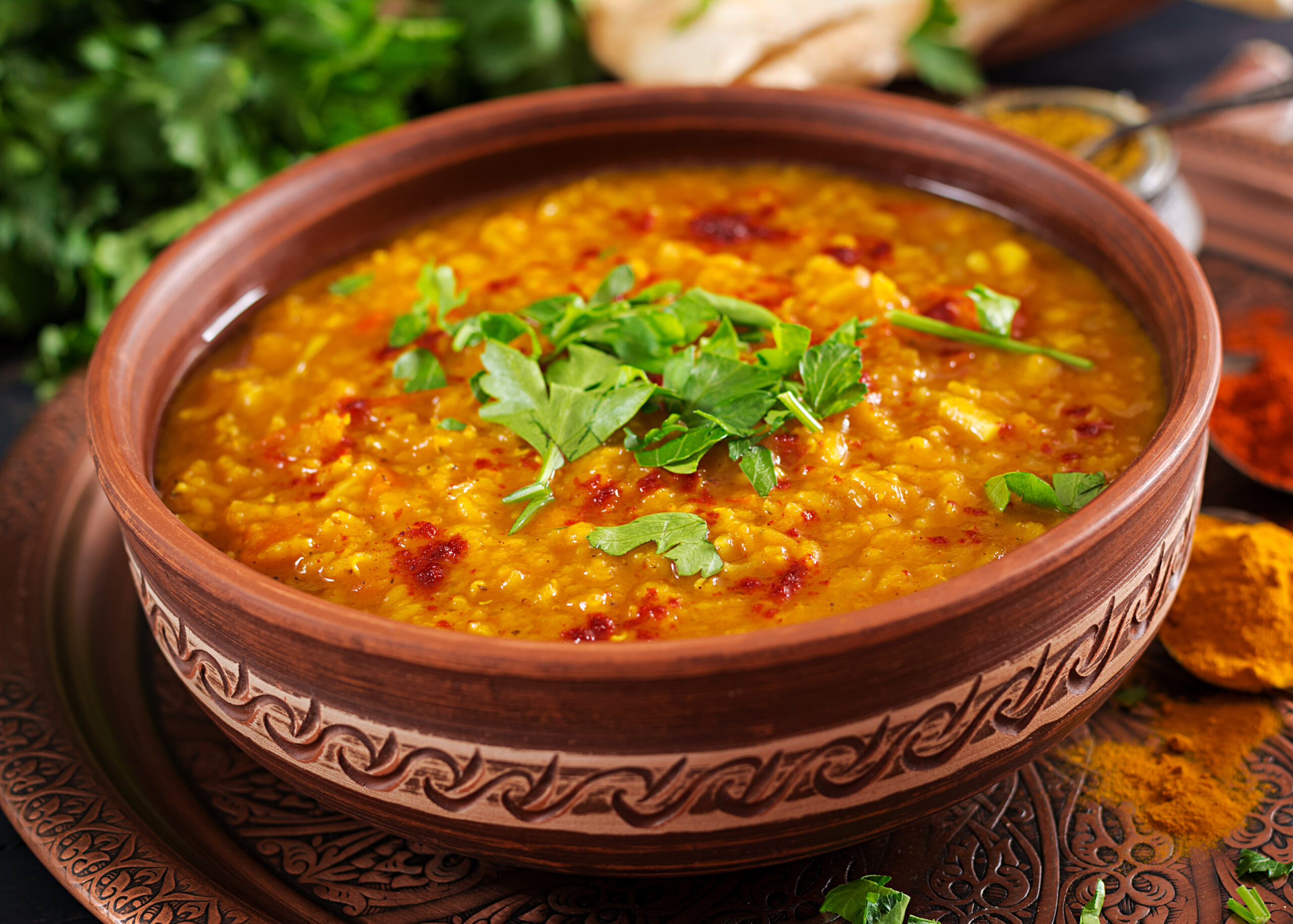 Yellow moong dal tadka in a bowl, garnished with coriander